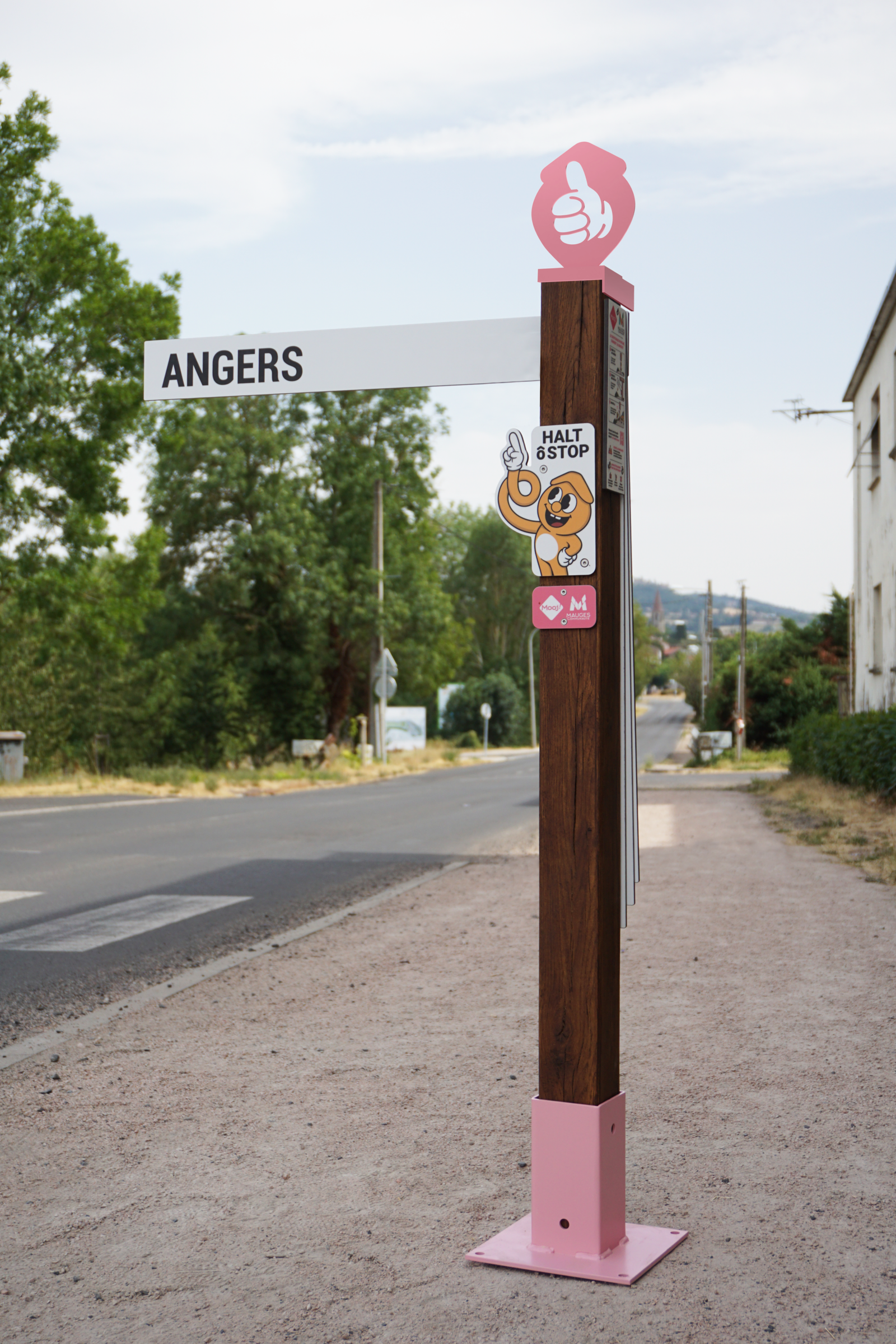 Arrêt PITÔ HALT ô STOP installé en bord de route, poteau bois avec plaque de destination Angers
